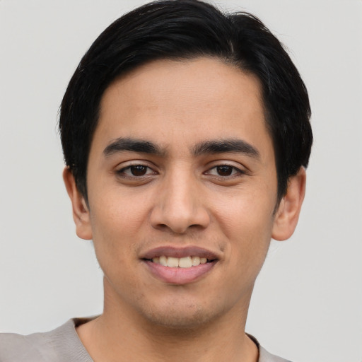 Joyful latino young-adult male with short  black hair and brown eyes