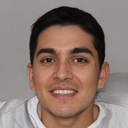 Joyful white young-adult male with short  black hair and brown eyes