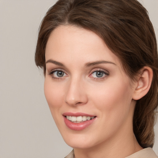 Joyful white young-adult female with medium  brown hair and grey eyes