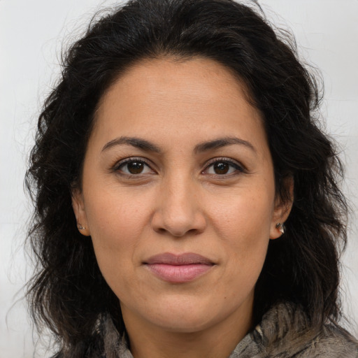Joyful latino adult female with long  brown hair and brown eyes