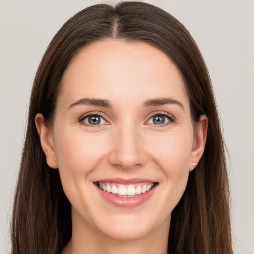 Joyful white young-adult female with long  brown hair and grey eyes