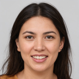 Joyful white young-adult female with long  brown hair and brown eyes