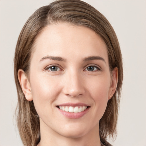 Joyful white young-adult female with medium  brown hair and grey eyes