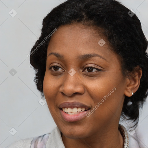 Joyful black young-adult female with short  black hair and brown eyes