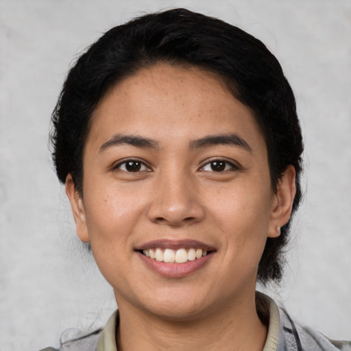 Joyful latino young-adult female with short  black hair and brown eyes