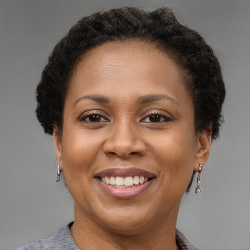 Joyful black adult female with short  brown hair and brown eyes
