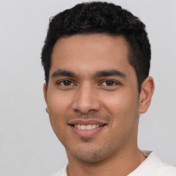 Joyful latino young-adult male with short  black hair and brown eyes