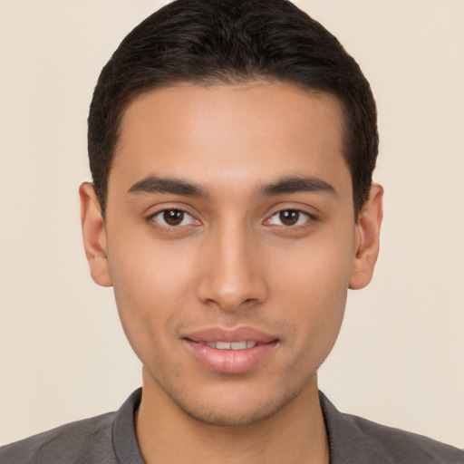 Joyful latino young-adult male with short  brown hair and brown eyes