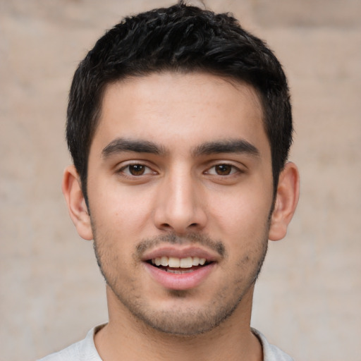 Joyful white young-adult male with short  black hair and brown eyes