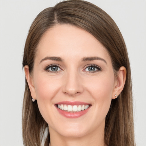 Joyful white young-adult female with long  brown hair and grey eyes