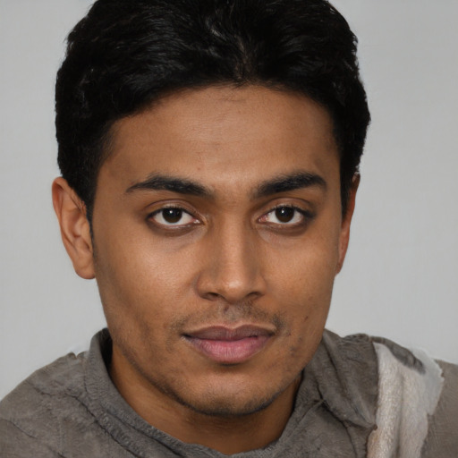 Joyful latino young-adult male with short  black hair and brown eyes