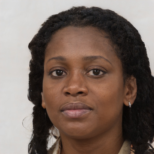 Joyful black young-adult female with long  brown hair and brown eyes