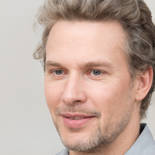 Joyful white adult male with short  brown hair and grey eyes