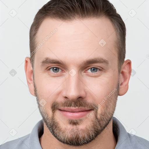 Joyful white young-adult male with short  brown hair and grey eyes