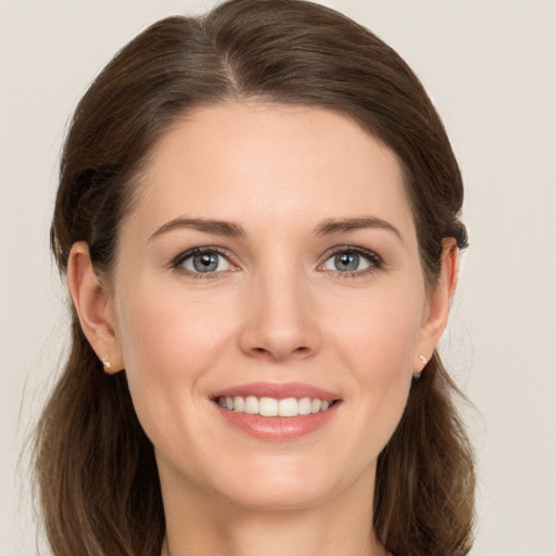 Joyful white young-adult female with medium  brown hair and grey eyes