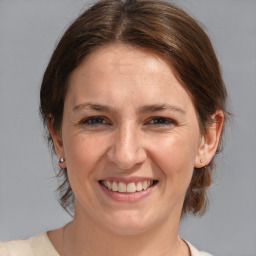 Joyful white adult female with medium  brown hair and blue eyes