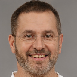 Joyful white adult male with short  brown hair and brown eyes