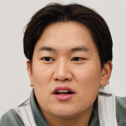 Joyful asian adult male with short  brown hair and brown eyes
