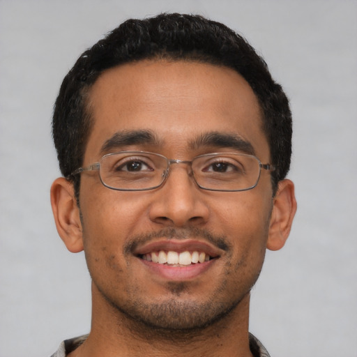 Joyful latino young-adult male with short  black hair and brown eyes