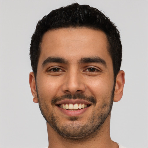 Joyful latino young-adult male with short  black hair and brown eyes