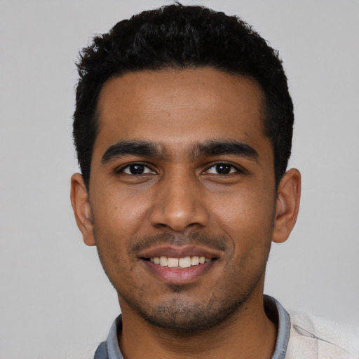 Joyful black young-adult male with short  black hair and brown eyes