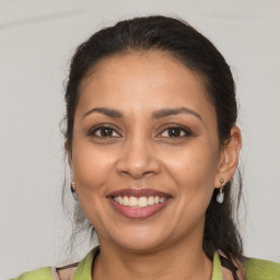 Joyful latino adult female with medium  brown hair and brown eyes