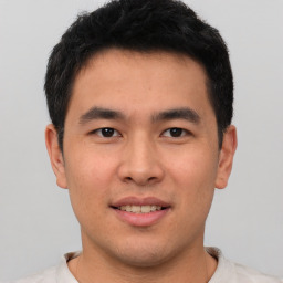 Joyful asian young-adult male with short  brown hair and brown eyes