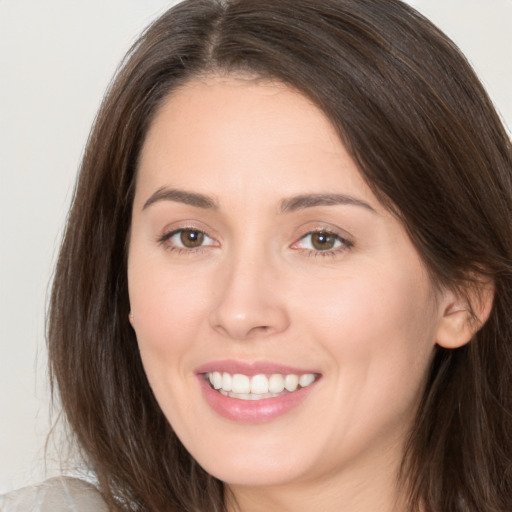 Joyful white young-adult female with long  brown hair and brown eyes