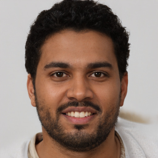 Joyful latino young-adult male with short  brown hair and brown eyes