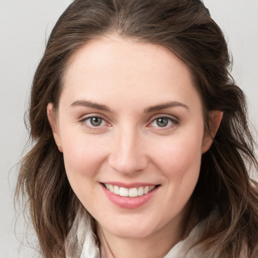 Joyful white young-adult female with long  brown hair and grey eyes