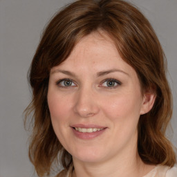 Joyful white young-adult female with medium  brown hair and blue eyes