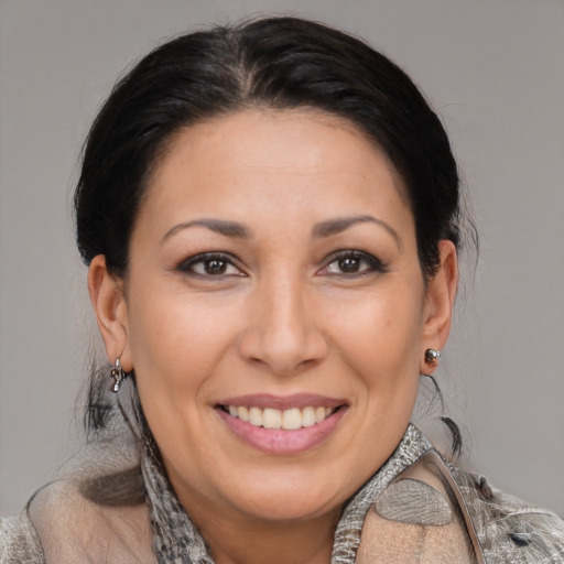 Joyful latino adult female with medium  brown hair and brown eyes