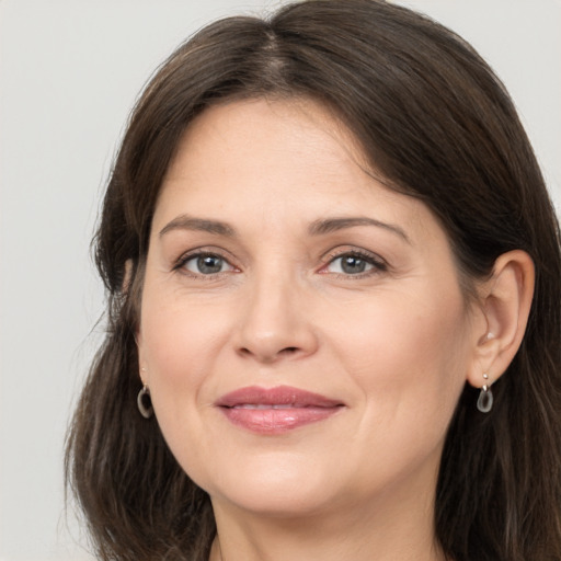 Joyful white adult female with long  brown hair and brown eyes