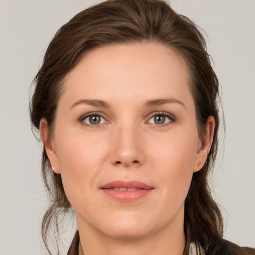 Joyful white young-adult female with medium  brown hair and grey eyes