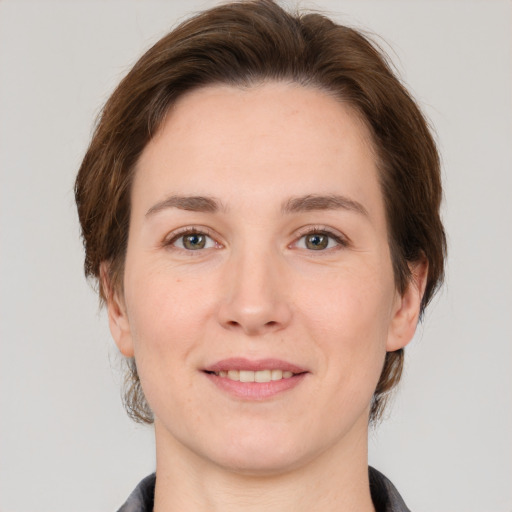 Joyful white young-adult female with medium  brown hair and grey eyes