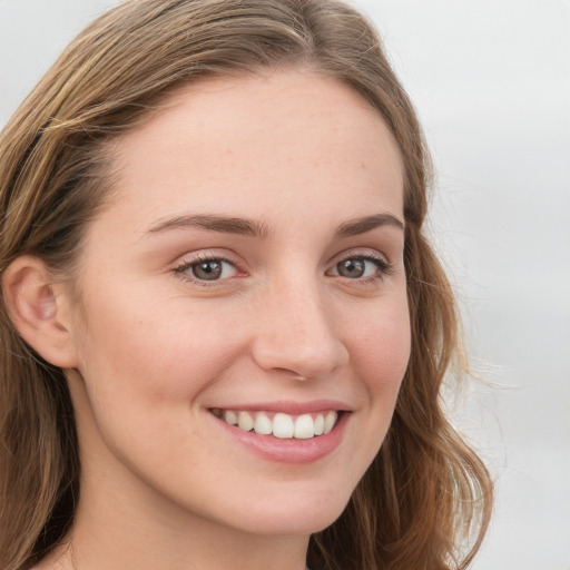 Joyful white young-adult female with long  brown hair and blue eyes