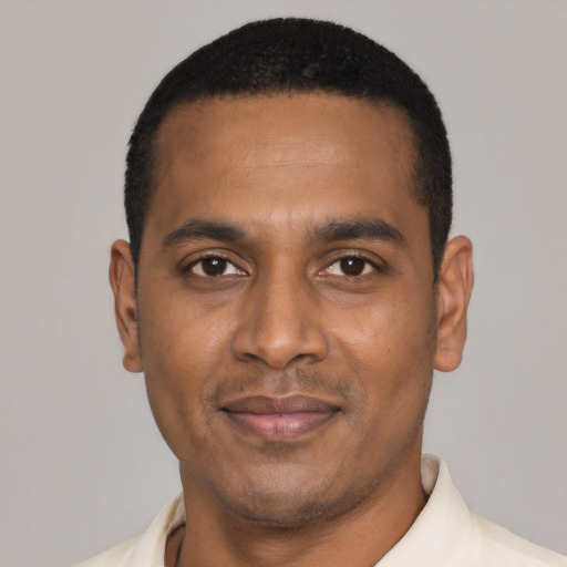 Joyful black young-adult male with short  black hair and brown eyes