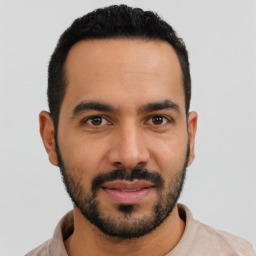 Joyful latino young-adult male with short  black hair and brown eyes