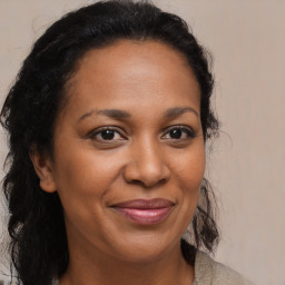 Joyful black adult female with long  brown hair and brown eyes