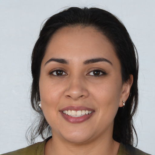 Joyful latino young-adult female with long  brown hair and brown eyes