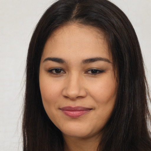 Joyful latino young-adult female with long  brown hair and brown eyes