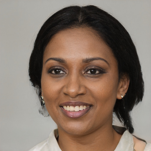 Joyful black adult female with medium  black hair and brown eyes