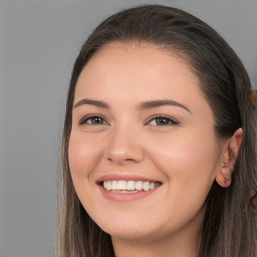 Joyful white young-adult female with long  brown hair and brown eyes