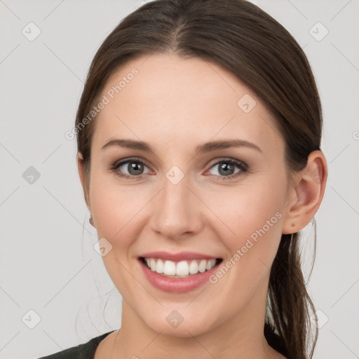 Joyful white young-adult female with long  brown hair and grey eyes