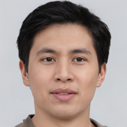 Joyful asian young-adult male with short  brown hair and brown eyes