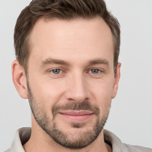 Joyful white young-adult male with short  brown hair and grey eyes