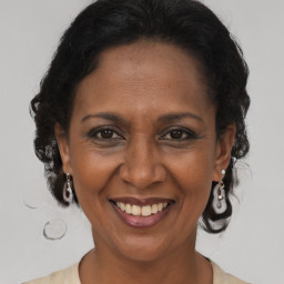 Joyful latino adult female with medium  brown hair and brown eyes