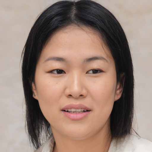 Joyful asian young-adult female with medium  brown hair and brown eyes