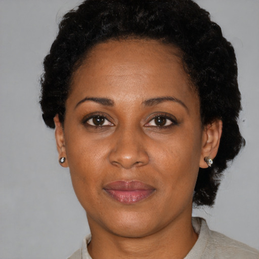 Joyful black adult female with short  black hair and brown eyes