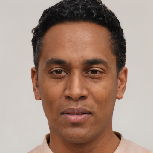 Joyful black young-adult male with short  black hair and brown eyes